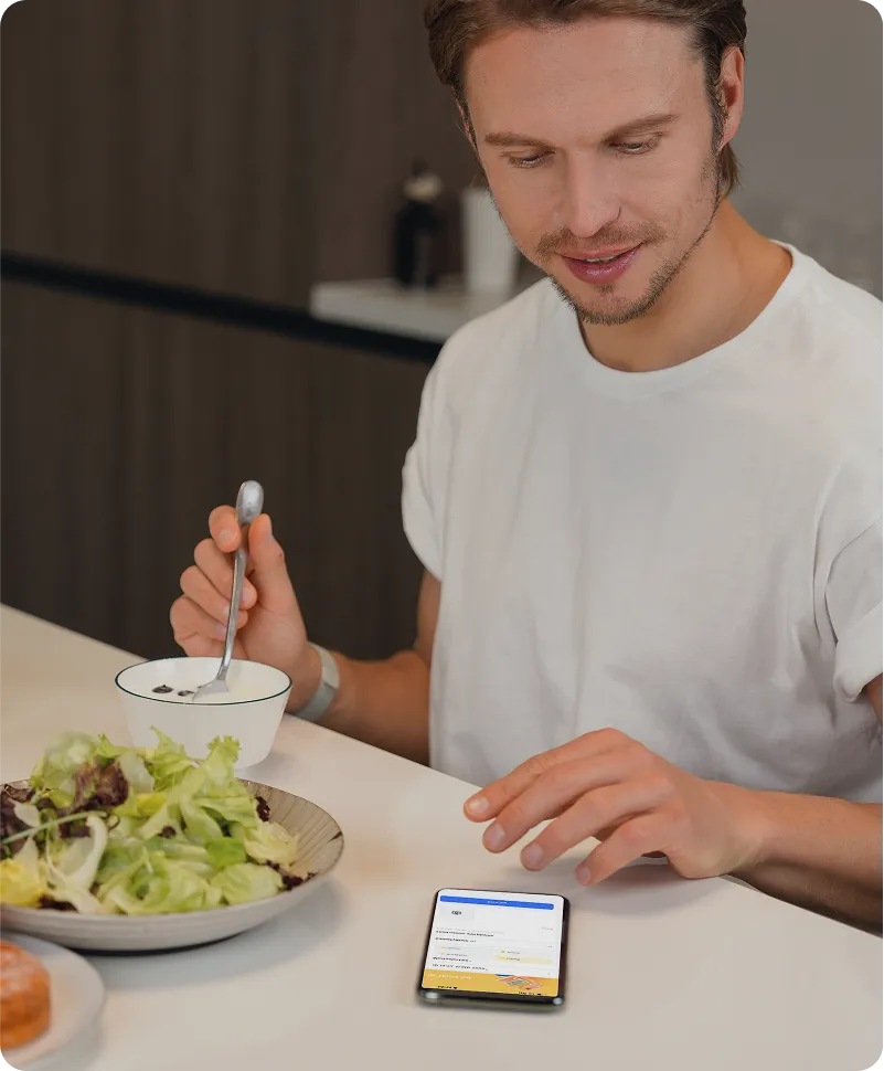 Une personne consulte son téléphone à table